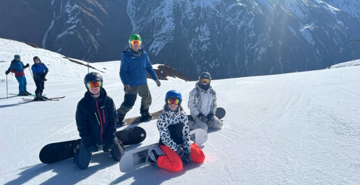 Snowboard monitor met tieners tijdens snowboardles